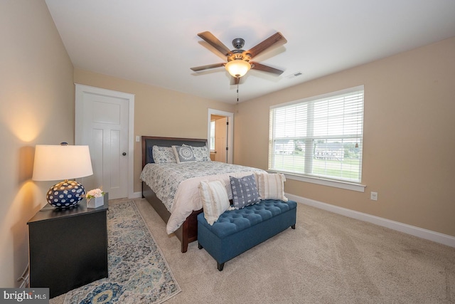 bedroom featuring baseboards, visible vents, a ceiling fan, and light colored carpet