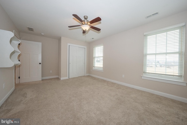 unfurnished bedroom featuring light carpet, baseboards, and visible vents