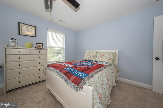 bedroom with baseboards, visible vents, a ceiling fan, and light colored carpet