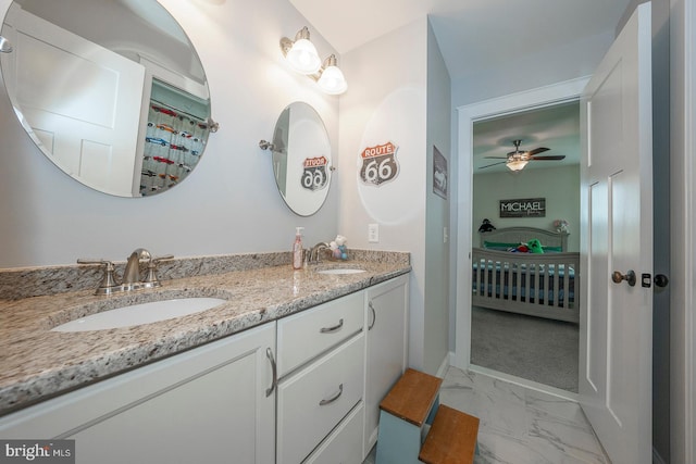 bathroom with connected bathroom, marble finish floor, a sink, and double vanity