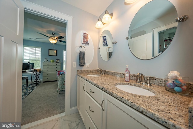 full bath with marble finish floor, a sink, baseboards, and double vanity