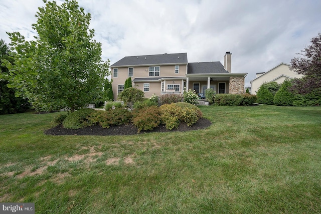 traditional-style house with a chimney and a front lawn