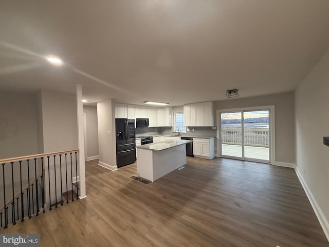 kitchen featuring a kitchen island, hardwood / wood-style floors, sink, white cabinets, and stainless steel appliances