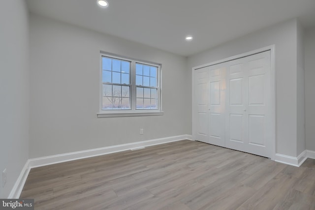 unfurnished bedroom featuring a closet and light hardwood / wood-style flooring