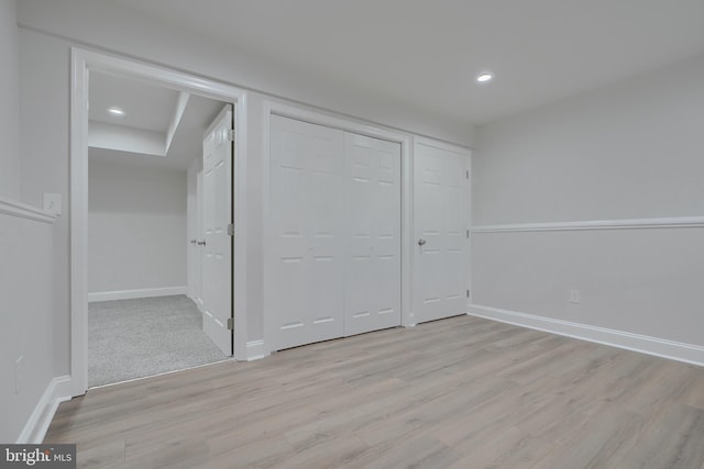 unfurnished bedroom featuring light hardwood / wood-style floors and a closet