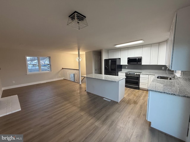 kitchen with stainless steel appliances, a center island, sink, and white cabinets