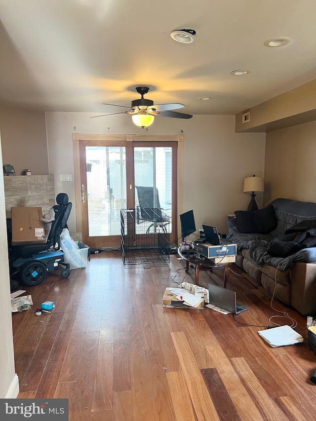 living room featuring wood-type flooring and ceiling fan