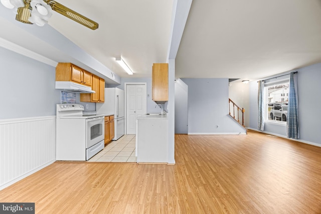 kitchen featuring ceiling fan, sink, white appliances, and light hardwood / wood-style flooring