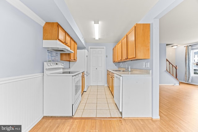 kitchen featuring sink, white appliances, and light hardwood / wood-style flooring