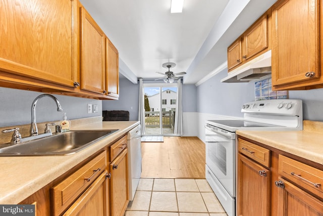 kitchen with light tile patterned flooring, white appliances, ceiling fan, and sink