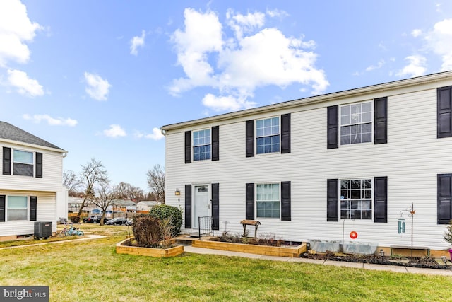 view of front of home with a front yard and central air condition unit