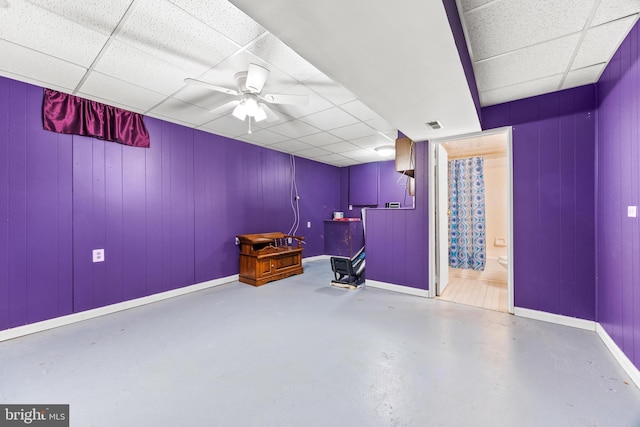 interior space with a paneled ceiling and ceiling fan