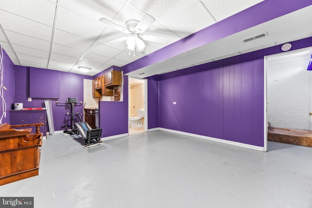 basement with ceiling fan and a drop ceiling