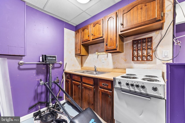 kitchen featuring electric stove, a paneled ceiling, and sink