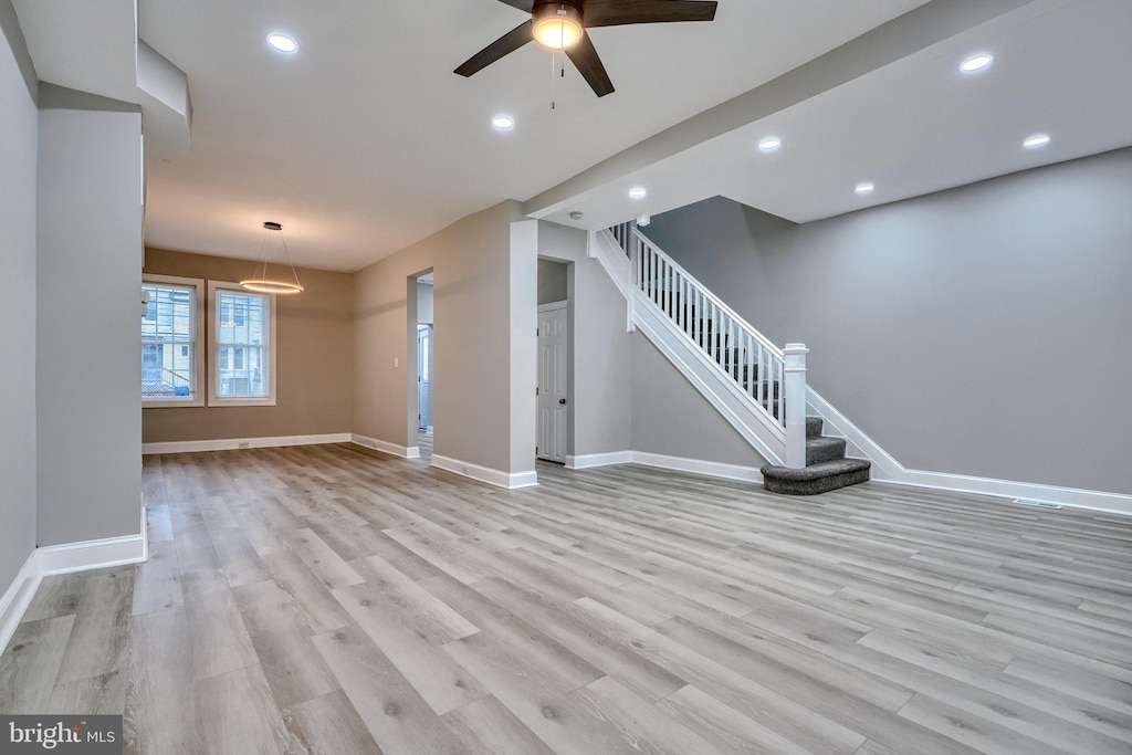 unfurnished living room with ceiling fan and light hardwood / wood-style floors