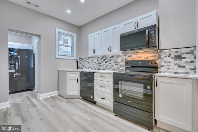 kitchen with white cabinets, beverage cooler, backsplash, black appliances, and light wood-type flooring