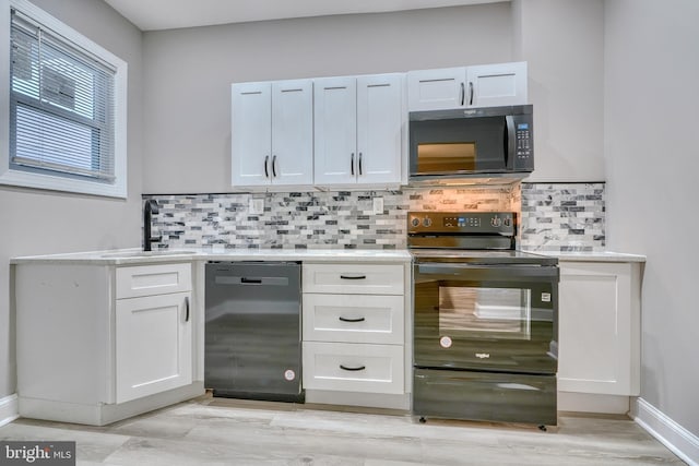 kitchen featuring tasteful backsplash, sink, black appliances, and white cabinets