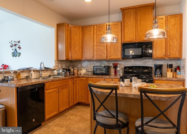 kitchen featuring pendant lighting, sink, a breakfast bar area, and black appliances