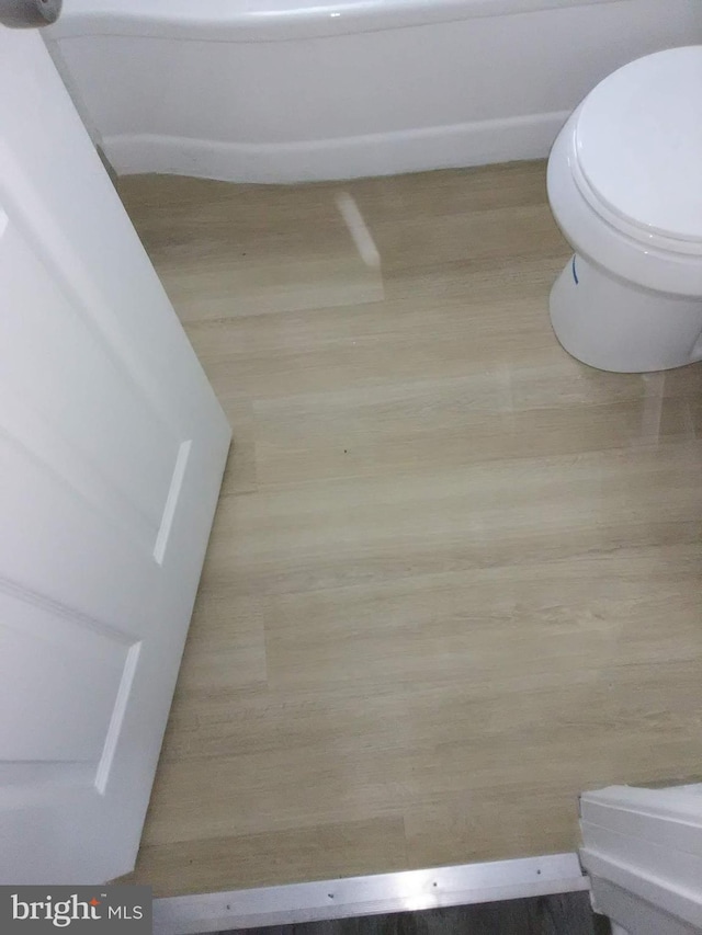 bathroom featuring wood-type flooring and toilet