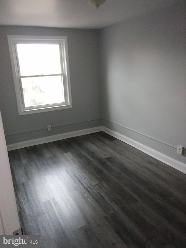 unfurnished room featuring dark wood-type flooring