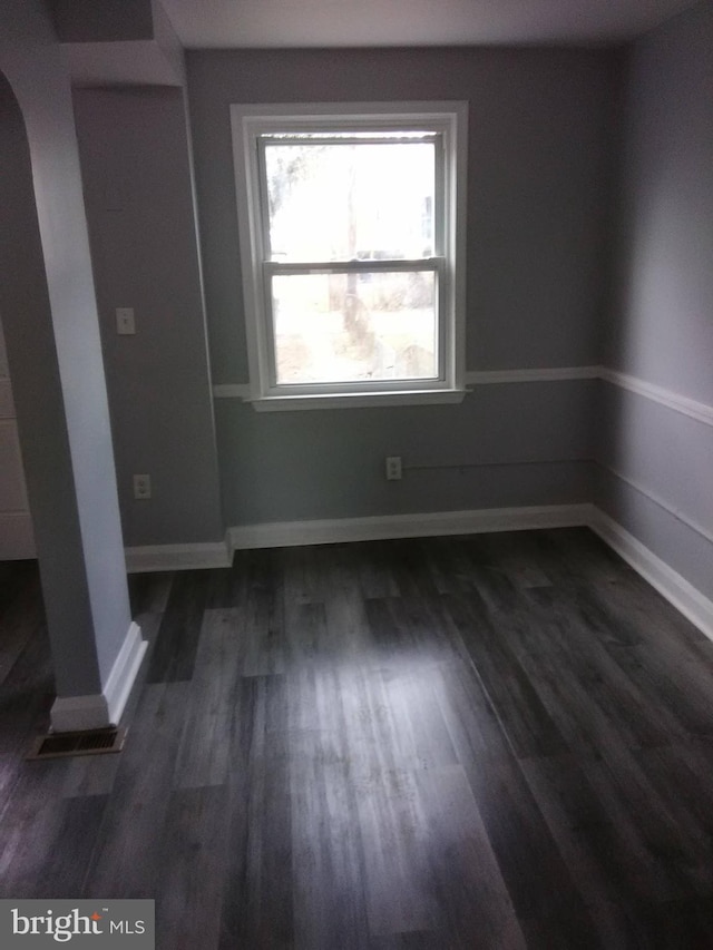 unfurnished room featuring dark wood-type flooring