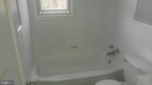 bathroom with toilet and tile walls