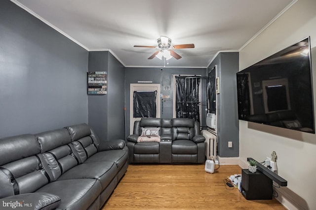 living room featuring light hardwood / wood-style flooring, ceiling fan, cooling unit, radiator heating unit, and ornamental molding