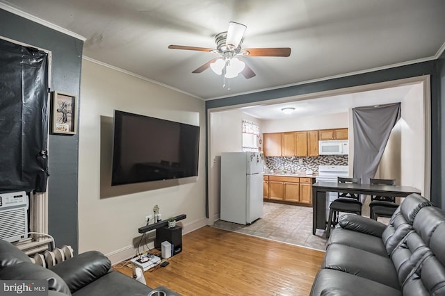 living room featuring ornamental molding, light hardwood / wood-style floors, and ceiling fan