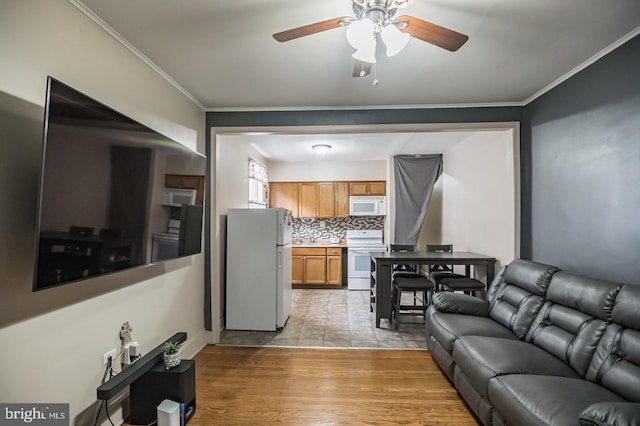 living room with ornamental molding, ceiling fan, and light wood-type flooring