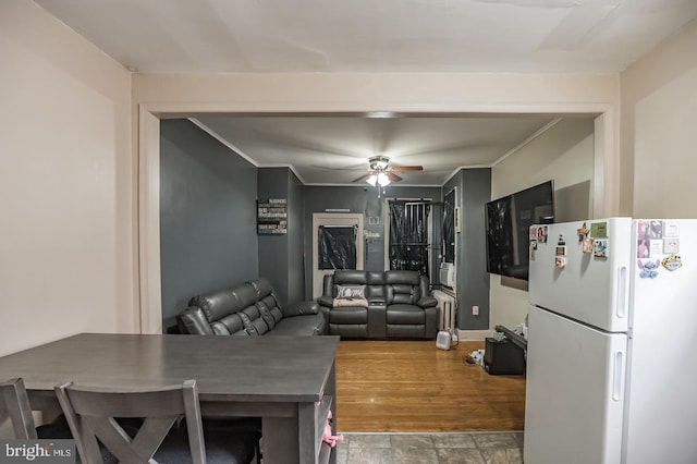 dining room with crown molding, ceiling fan, and wood-type flooring