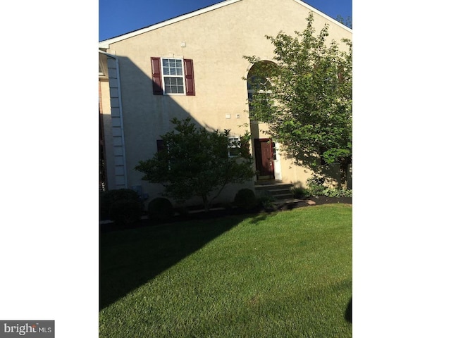 view of side of home with a yard