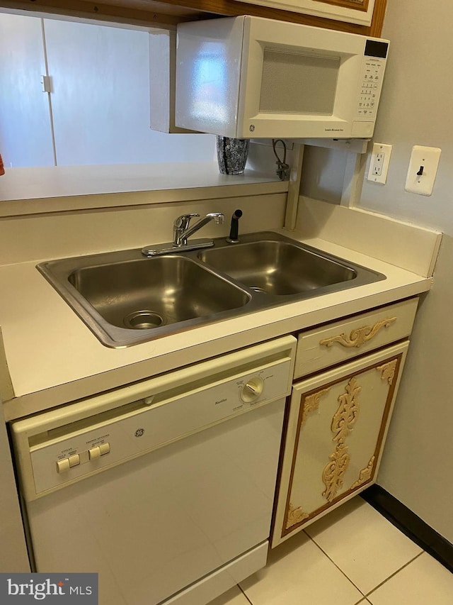 kitchen with light tile patterned flooring, dishwasher, and sink