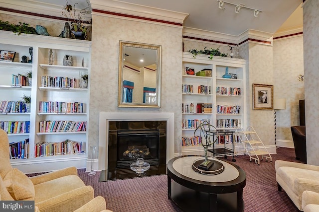 sitting room with track lighting, ornamental molding, built in features, and dark colored carpet