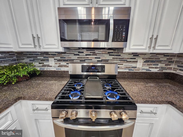 kitchen featuring tasteful backsplash, dark stone counters, white cabinets, and appliances with stainless steel finishes