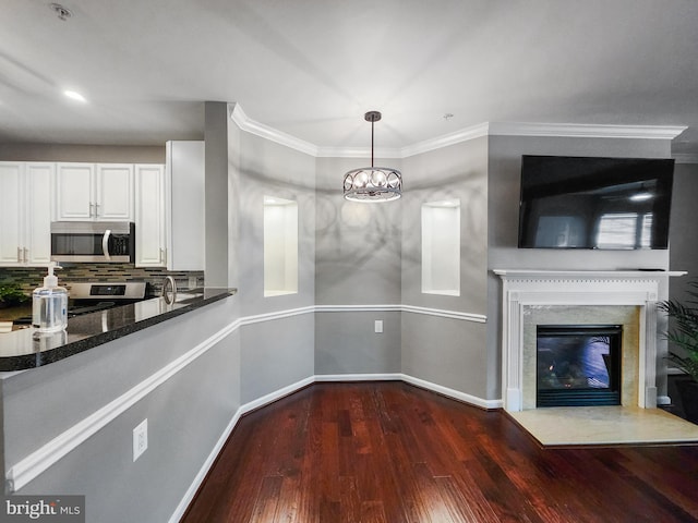 kitchen featuring white cabinetry, decorative light fixtures, dark stone countertops, dark hardwood / wood-style floors, and stainless steel appliances