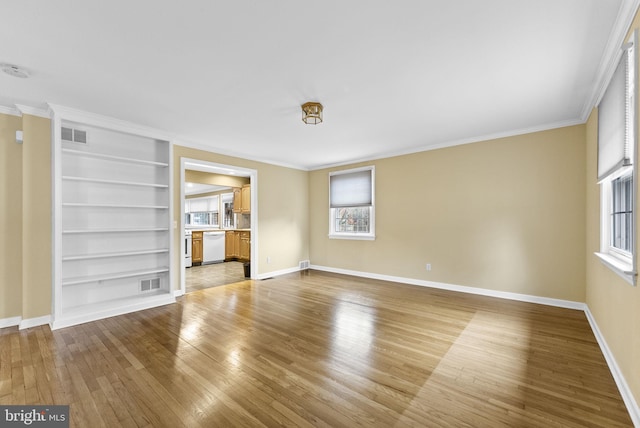 unfurnished living room with hardwood / wood-style flooring, crown molding, and built in features