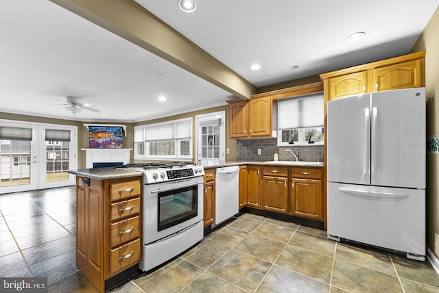 kitchen with white appliances, kitchen peninsula, sink, and decorative backsplash