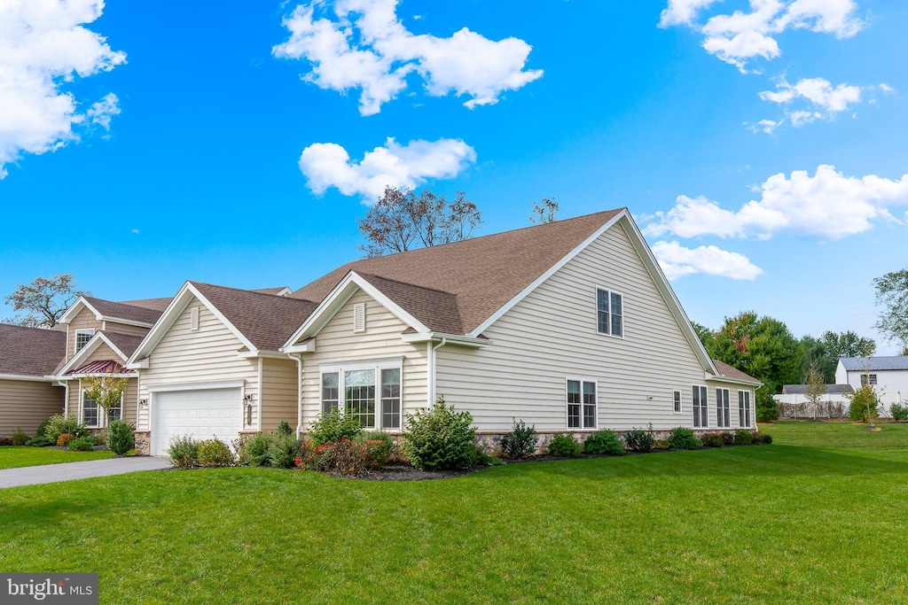 view of front of home with a garage and a front lawn