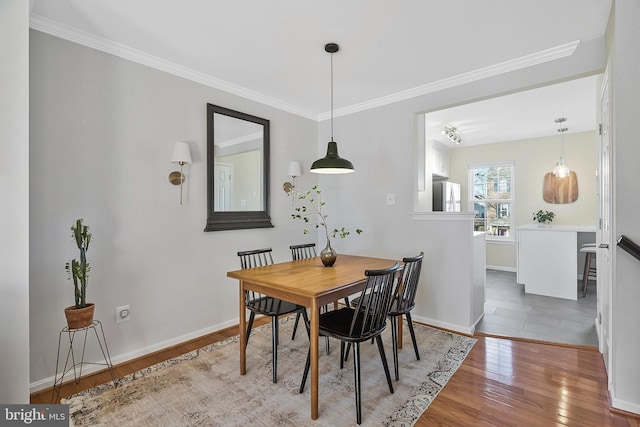 dining space featuring ornamental molding and hardwood / wood-style floors