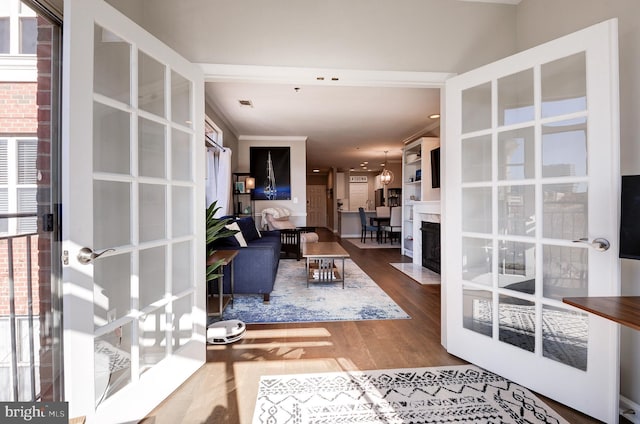 living room with hardwood / wood-style flooring, ornamental molding, and a wealth of natural light