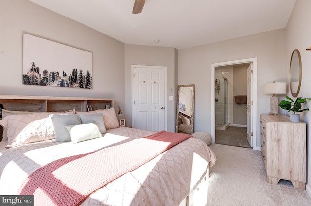 bedroom featuring ensuite bathroom, light colored carpet, and ceiling fan