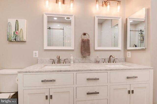 bathroom with vanity, toilet, and a shower with shower door