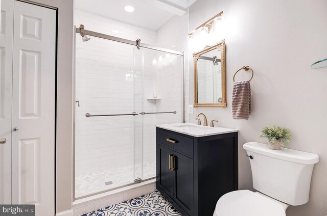 bathroom featuring vanity, a shower with shower door, and toilet