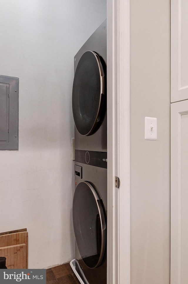 laundry area featuring stacked washer / dryer and electric panel