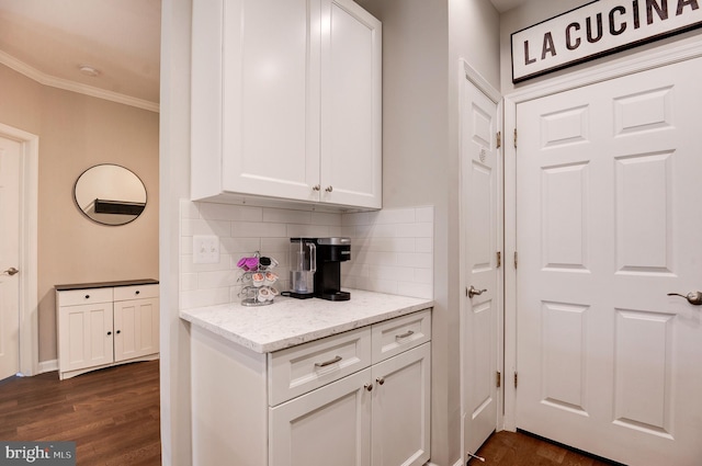 bar featuring white cabinetry, light stone counters, and crown molding