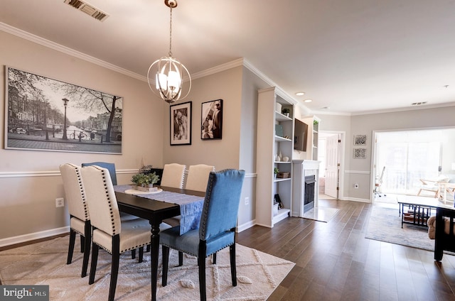 dining space with ornamental molding, dark hardwood / wood-style floors, and a chandelier