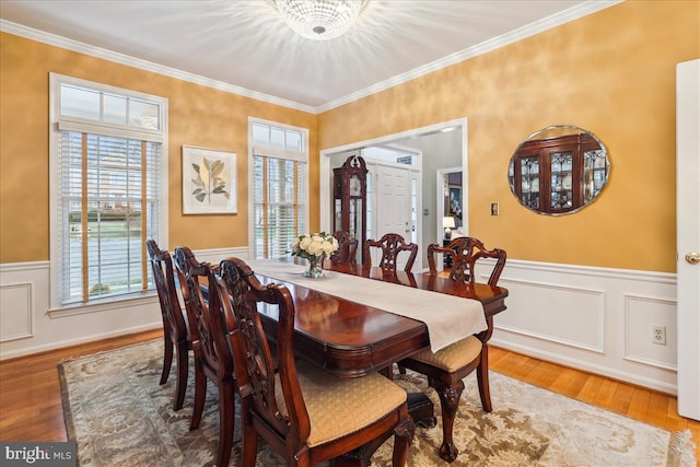 dining room with ornamental molding, wood-type flooring, and a notable chandelier