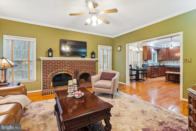 living room with crown molding, light wood-type flooring, and a fireplace