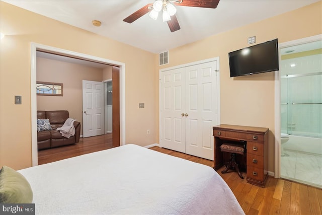 bedroom with ensuite bath, wood-type flooring, a closet, and ceiling fan