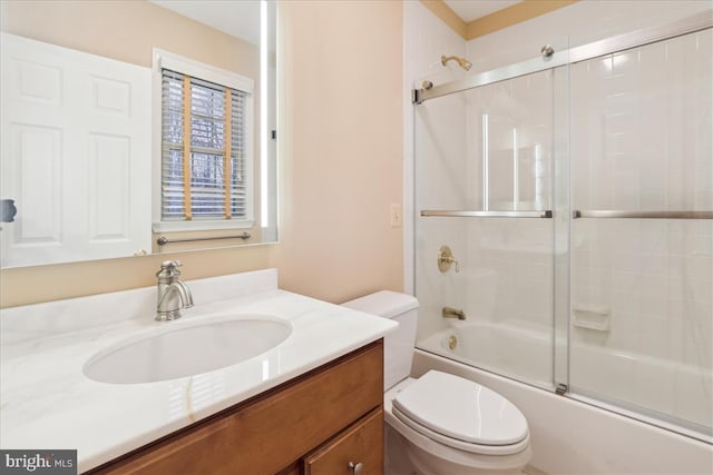 full bathroom featuring enclosed tub / shower combo, vanity, and toilet